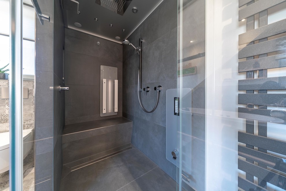 Inspiration for a large contemporary bathroom in Stuttgart with light wood cabinets, a hot tub, a curbless shower, a two-piece toilet, gray tile, stone tile, white walls, ceramic floors, with a sauna, a vessel sink, grey floor, a hinged shower door and brown benchtops.