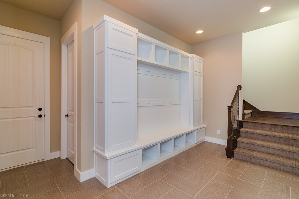 Large transitional porcelain tile mudroom photo with beige walls