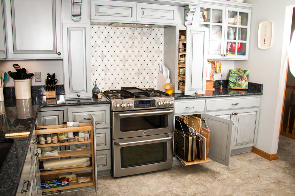 Example of a large transitional u-shaped porcelain tile and beige floor eat-in kitchen design in Milwaukee with an undermount sink, raised-panel cabinets, gray cabinets, granite countertops, white backsplash, marble backsplash, stainless steel appliances and no island