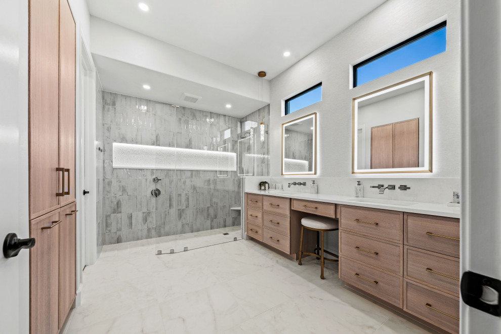 Walk-in shower - transitional master gray tile and porcelain tile porcelain tile, white floor and double-sink walk-in shower idea with shaker cabinets, light wood cabinets, a two-piece toilet, white walls, an undermount sink, quartz countertops, white countertops, a niche and a built-in vanity