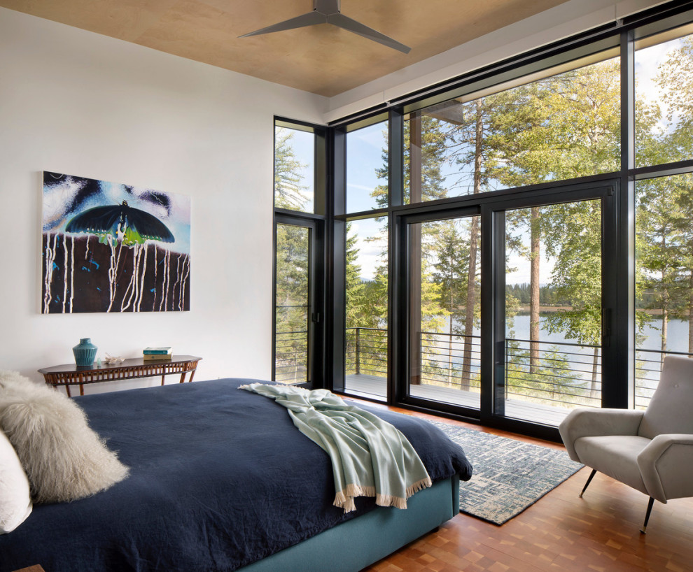 Large contemporary master bedroom in Other with white walls, medium hardwood flooring and a wood ceiling.