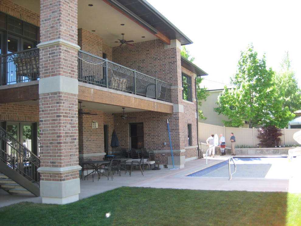 Inspiration for a large timeless backyard concrete patio remodel in Salt Lake City with a roof extension