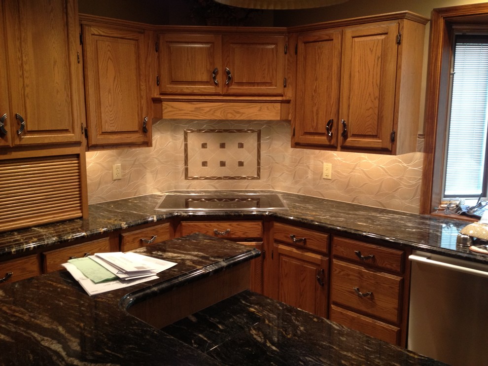 Inspiration for a mid-sized u-shaped eat-in kitchen remodel with a double-bowl sink, medium tone wood cabinets, beige backsplash, ceramic backsplash and stainless steel appliances