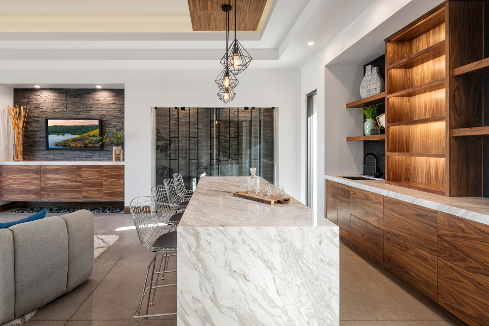 Inspiration for a contemporary seated home bar in Phoenix with an undermount sink, flat-panel cabinets, medium wood cabinets, black splashback, concrete floors, grey floor and white benchtop.