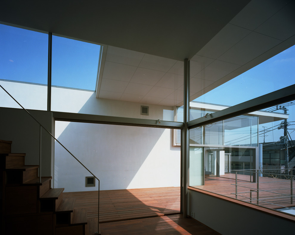 Cette photo montre une terrasse moderne avec une extension de toiture.