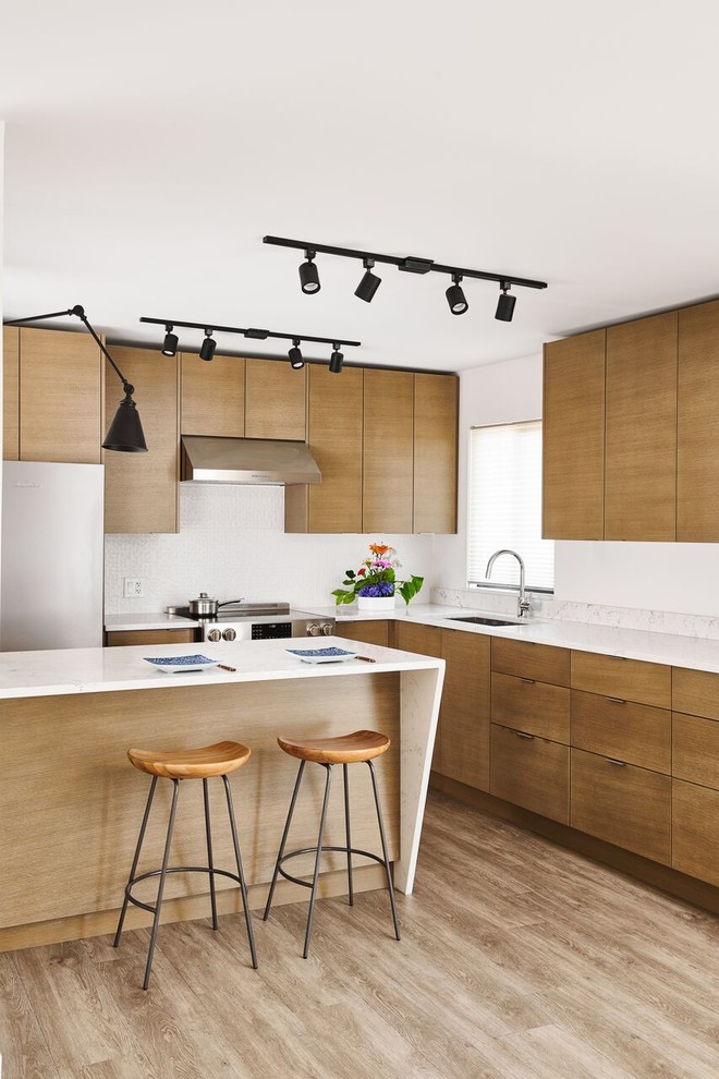 Design ideas for a mid-sized contemporary l-shaped eat-in kitchen in Vancouver with an undermount sink, flat-panel cabinets, medium wood cabinets, quartzite benchtops, white splashback, stainless steel appliances, vinyl floors, with island, brown floor, white benchtop and stone slab splashback.