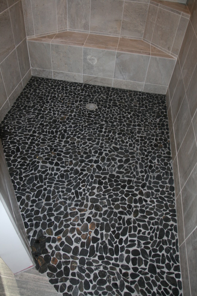 This is an example of a large modern master bathroom in DC Metro with a curbless shower, black tile and pebble tile.