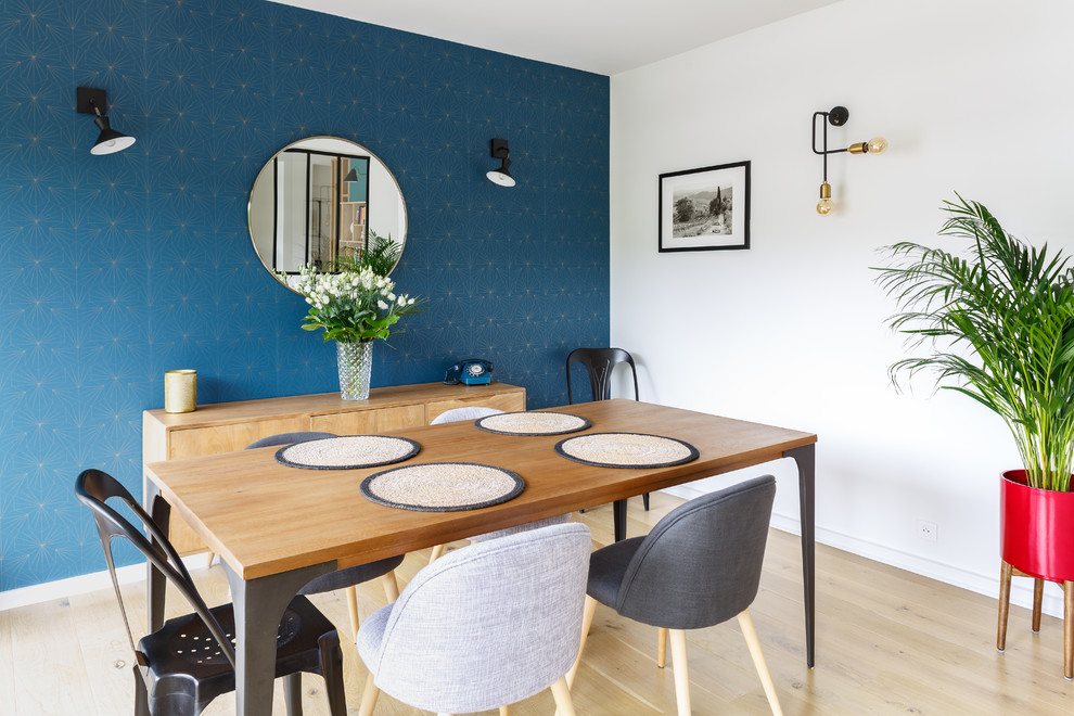 This is an example of a beach style dining room in Paris with blue walls, light hardwood floors and no fireplace.