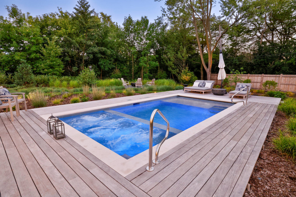 Esempio di una piscina classica rettangolare di medie dimensioni e dietro casa con una vasca idromassaggio e pedane