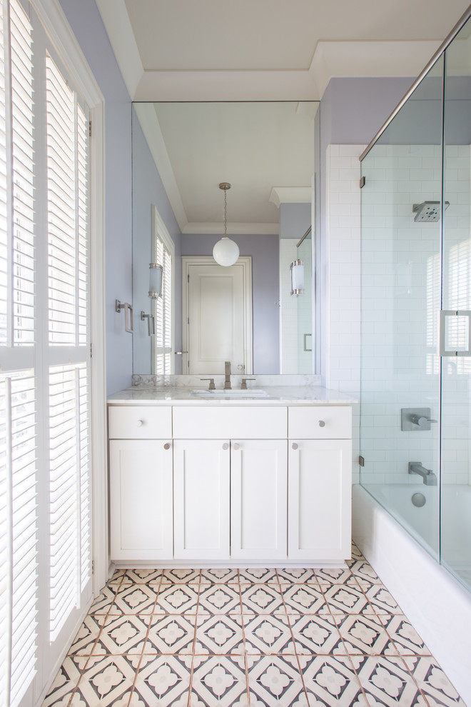 Photo of a mid-sized contemporary kids bathroom in New Orleans with recessed-panel cabinets, white cabinets, a freestanding tub, an alcove shower, black and white tile, stone slab, purple walls, an undermount sink and marble benchtops.