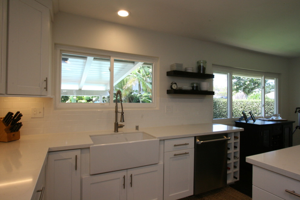 Inspiration for a large transitional u-shaped dark wood floor eat-in kitchen remodel in Orange County with a farmhouse sink, shaker cabinets, white cabinets, quartz countertops, white backsplash, ceramic backsplash, stainless steel appliances and an island