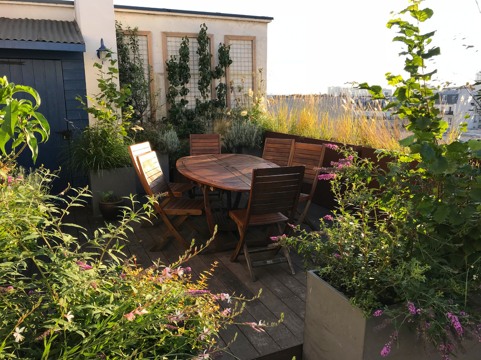 This is an example of a mid-sized country rooftop and rooftop deck in Paris with a container garden and a pergola.