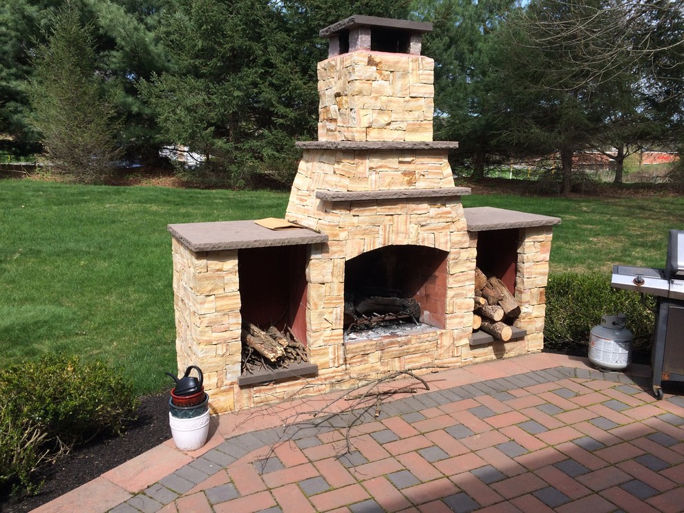 Photo of a large traditional backyard patio in Philadelphia with a fire feature, brick pavers and no cover.