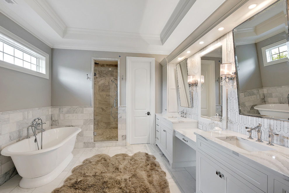 Inspiration for a traditional master bathroom in Chicago with recessed-panel cabinets, white cabinets, a japanese tub, an alcove shower, gray tile, white tile, marble, grey walls, marble floors, an undermount sink, white floor, a hinged shower door and white benchtops.