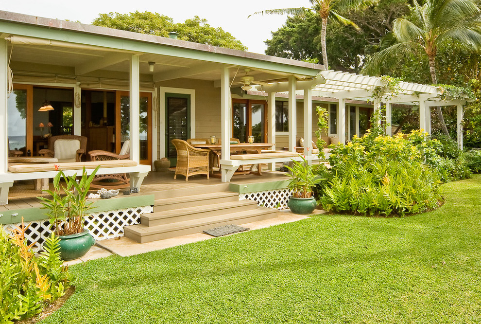 This is an example of a large tropical backyard verandah in Hawaii with decking and a pergola.