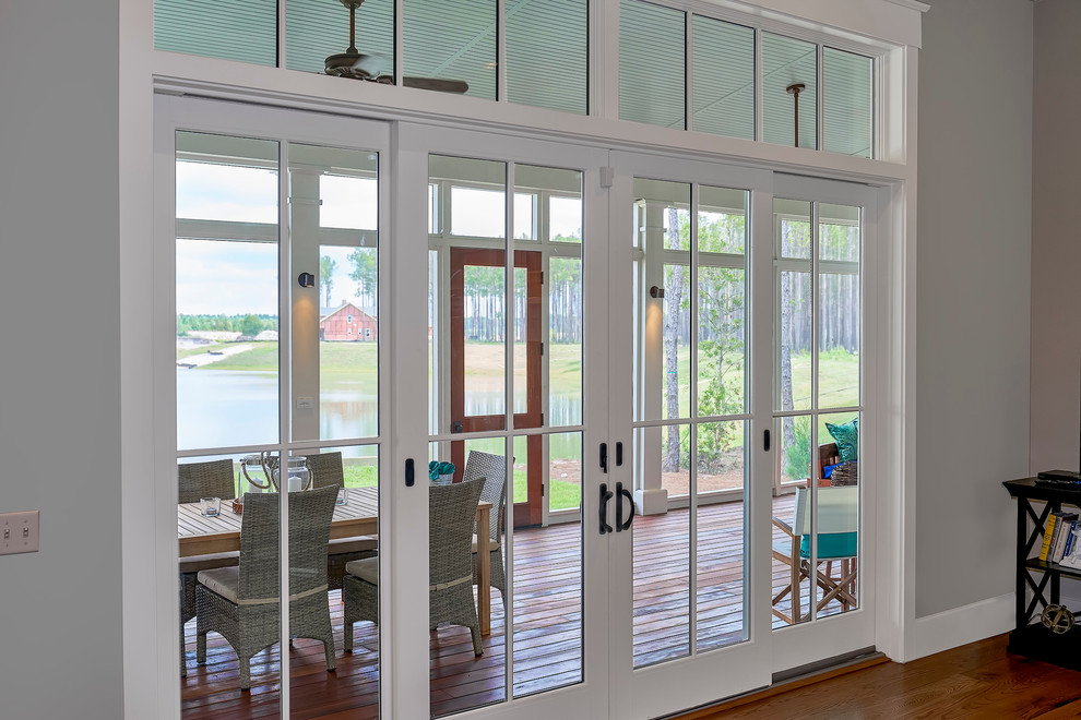 Inspiration for a large transitional backyard screened-in verandah in Charleston with decking and a roof extension.