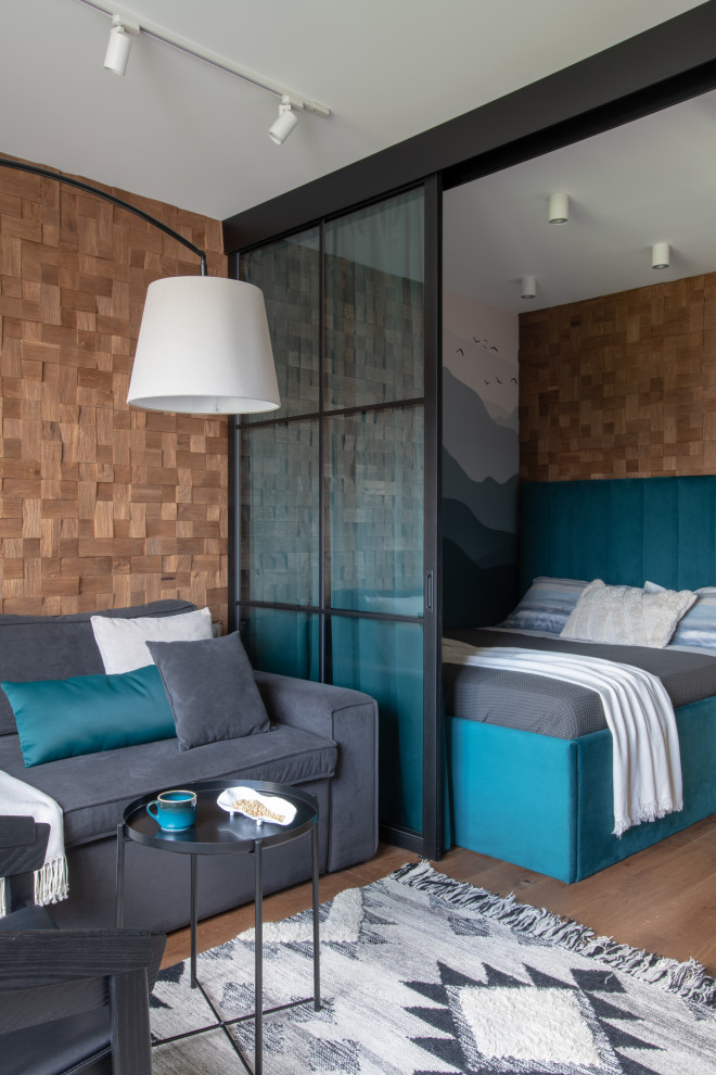 Kleines Nordisches Hauptschlafzimmer mit bunten Wänden, braunem Holzboden, braunem Boden und Wandpaneelen in Moskau