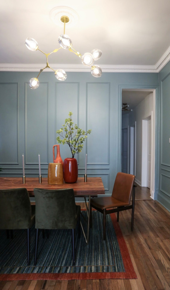 Idee per una sala da pranzo aperta verso la cucina tradizionale di medie dimensioni con pareti blu, pavimento in legno verniciato, pavimento marrone e pannellatura