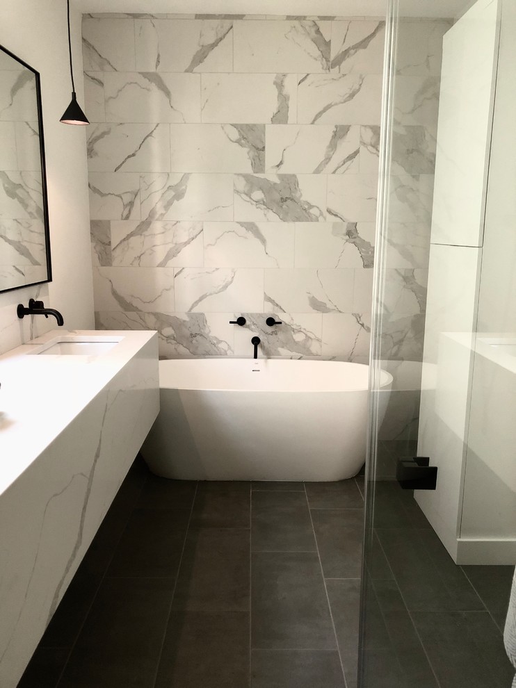 Large contemporary master bathroom in Charleston with flat-panel cabinets, white cabinets, a freestanding tub, a curbless shower, white tile, marble, slate floors, an undermount sink, marble benchtops, grey floor, a hinged shower door and white benchtops.