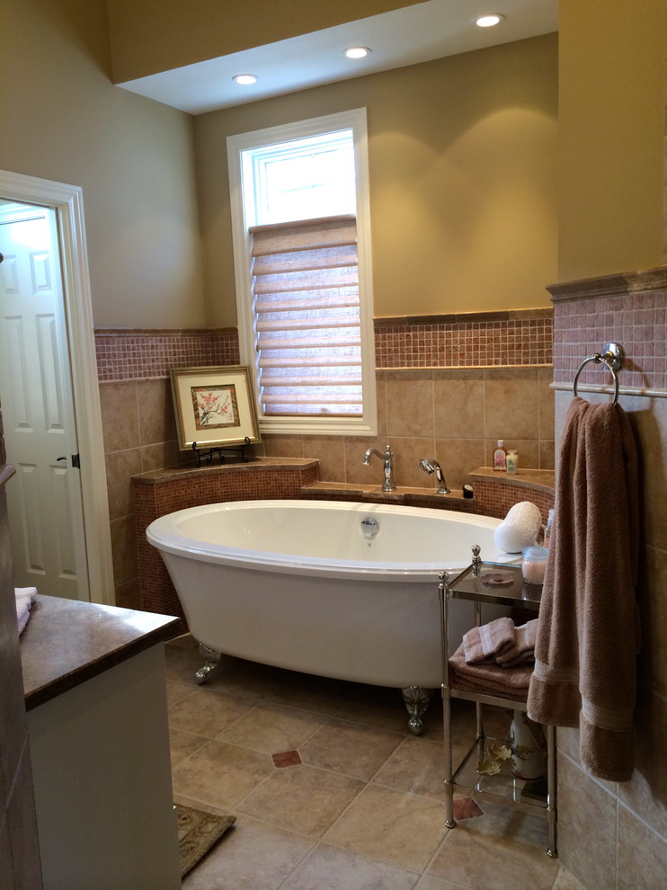 Design ideas for a mid-sized transitional bathroom in Cleveland with an undermount sink, white cabinets, limestone benchtops, a claw-foot tub, beige tile, mosaic tile, brown walls, beige floor and raised-panel cabinets.