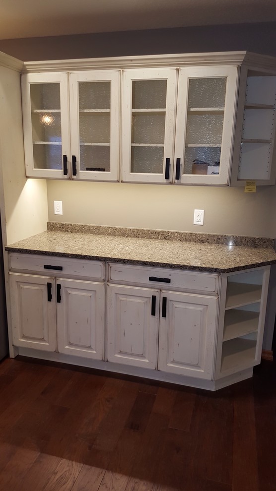 Large transitional galley medium tone wood floor open concept kitchen photo with a farmhouse sink, raised-panel cabinets, white cabinets, quartz countertops, stainless steel appliances and an island