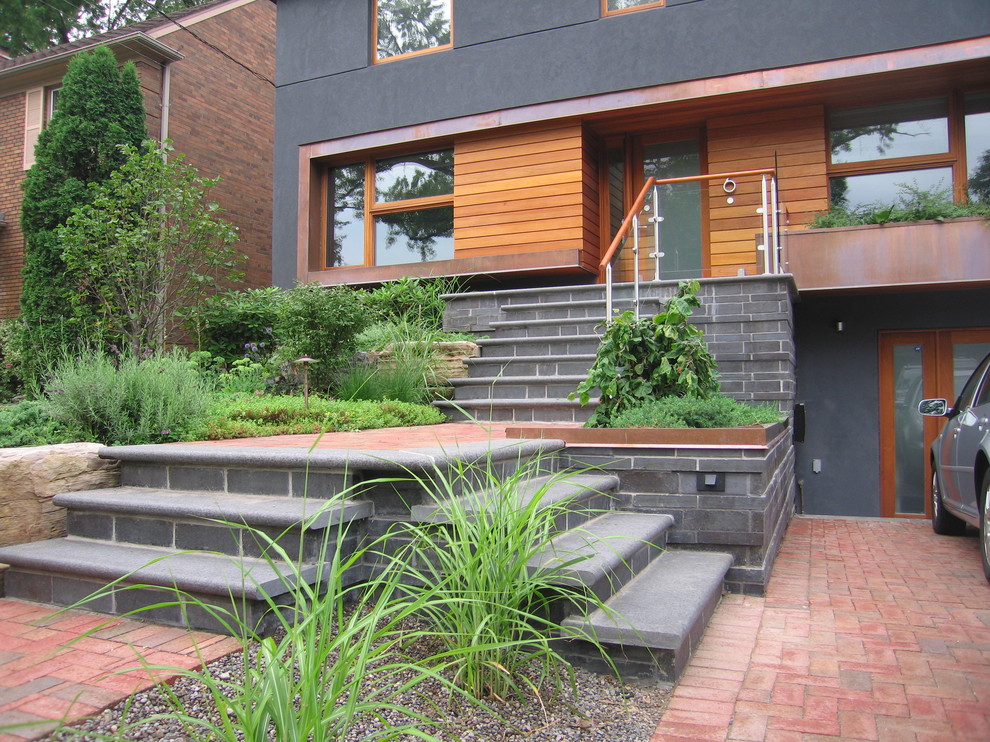 Inspiration for a large transitional three-storey stucco grey exterior in Toronto.