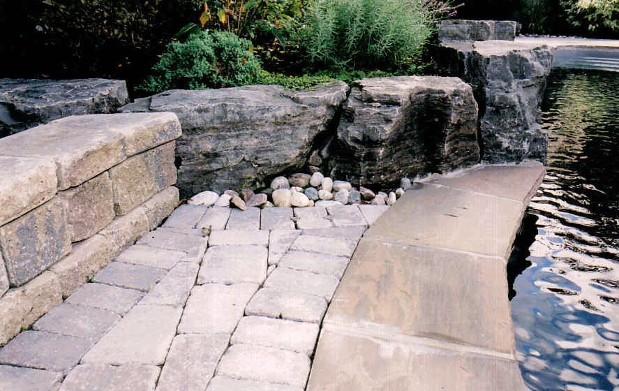 Pool fountain - mid-sized transitional backyard concrete paver and freeform pool fountain idea in Toronto
