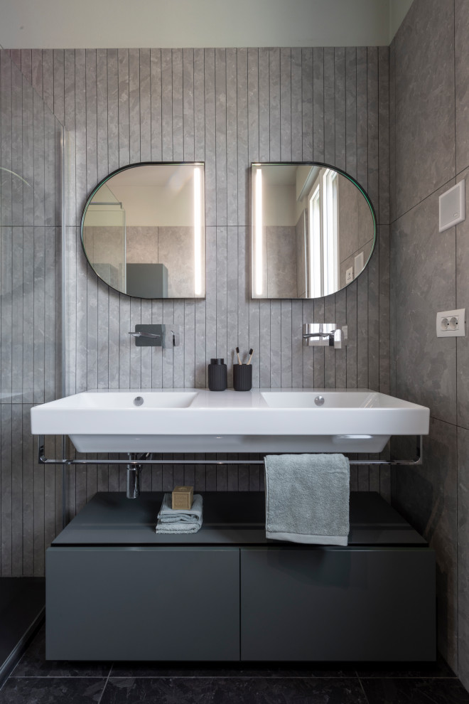 Exempel på ett mellanstort modernt badrum med dusch, med gröna skåp, en hörndusch, en vägghängd toalettstol, grå kakel, porslinskakel, grå väggar, klinkergolv i porslin, svart golv och dusch med gångjärnsdörr