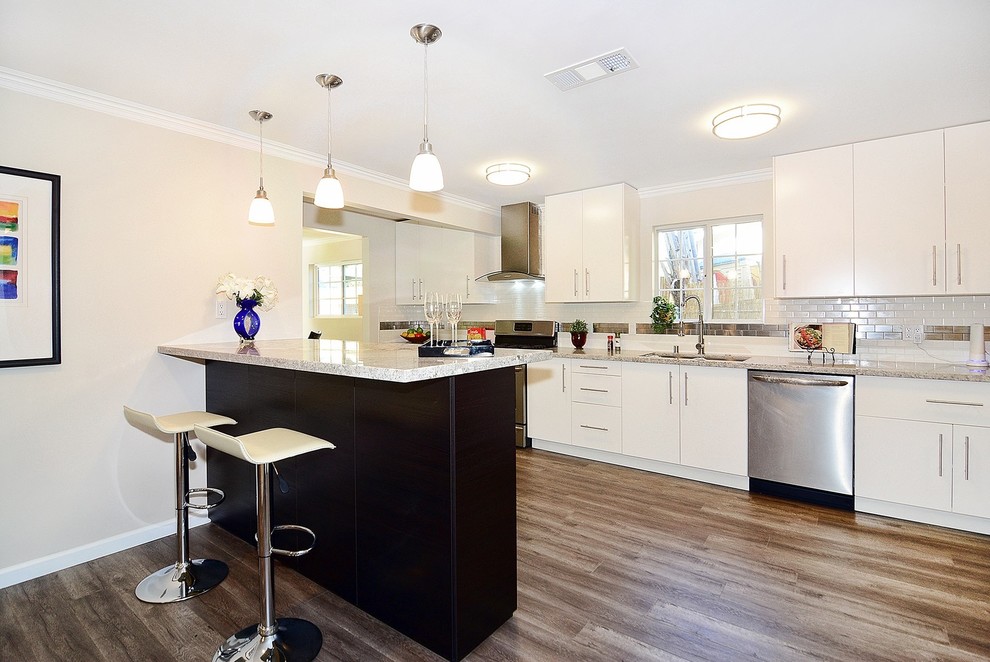 Inspiration for a large transitional single-wall medium tone wood floor open concept kitchen remodel with a single-bowl sink, flat-panel cabinets, white cabinets, multicolored backsplash, stainless steel appliances and a peninsula