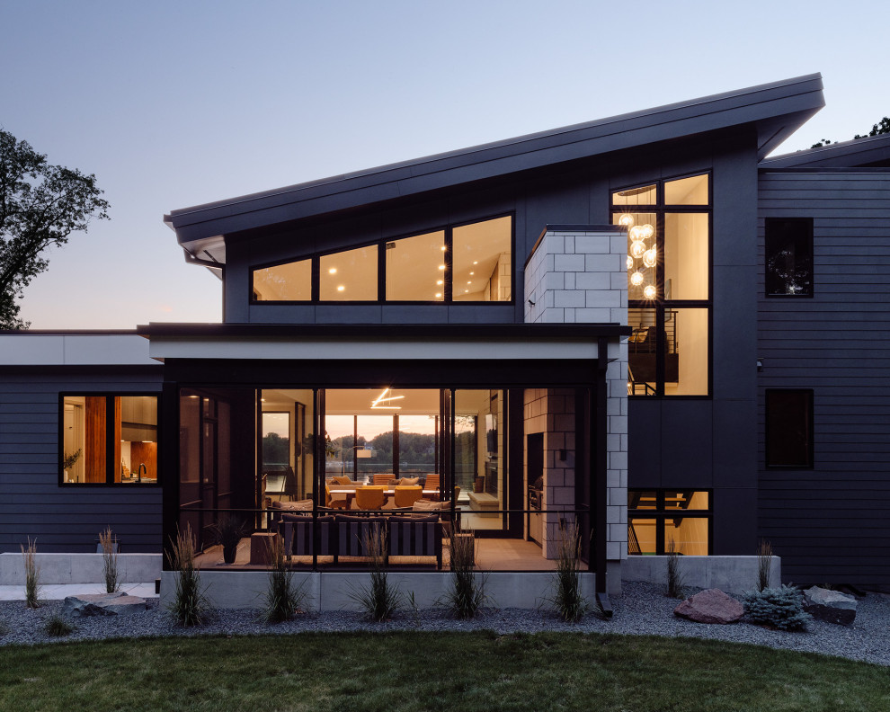Réalisation d'une grande façade de maison noire minimaliste en bardage à clin à deux étages et plus avec un revêtement mixte, un toit en appentis, un toit mixte et un toit noir.