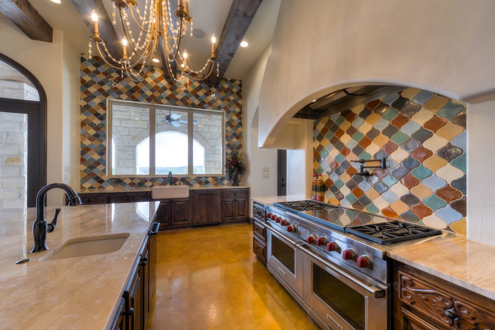 This is an example of a large mediterranean l-shaped separate kitchen in Austin with a farmhouse sink, medium wood cabinets, multi-coloured splashback, stainless steel appliances and with island.