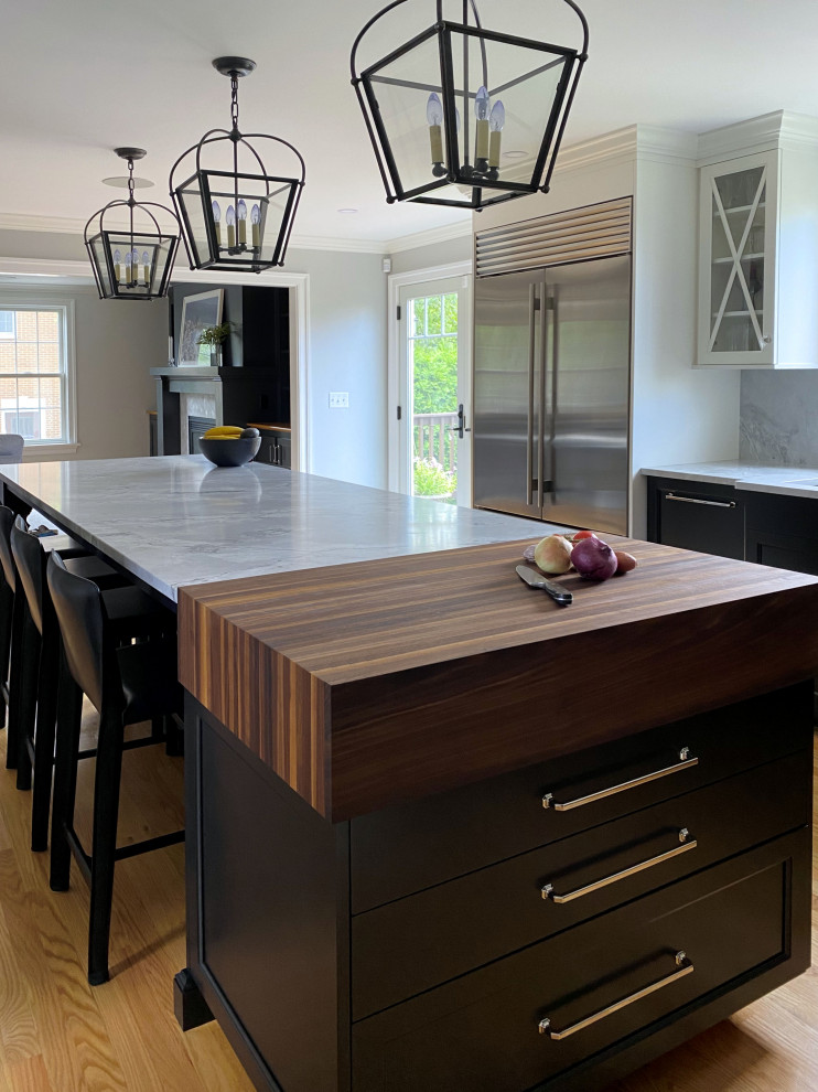 Inspiration for a traditional kitchen in Boston with an undermount sink, shaker cabinets, black cabinets, quartzite benchtops, grey splashback, stainless steel appliances, medium hardwood floors, with island and grey benchtop.