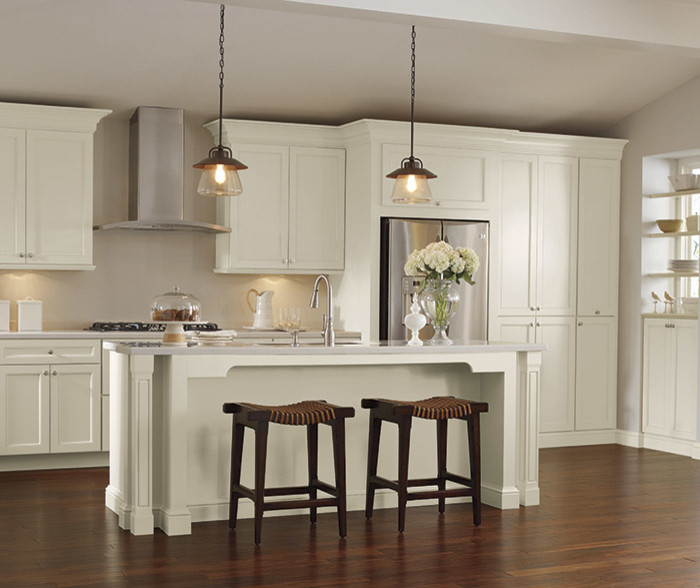 Inspiration for a large transitional l-shaped medium tone wood floor and brown floor eat-in kitchen remodel in Denver with white cabinets, an island, an undermount sink, recessed-panel cabinets, solid surface countertops, beige backsplash, subway tile backsplash and stainless steel appliances