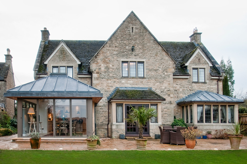 Inspiration for a large traditional brown exterior in Oxfordshire with stone veneer, a gable roof and a shingle roof.