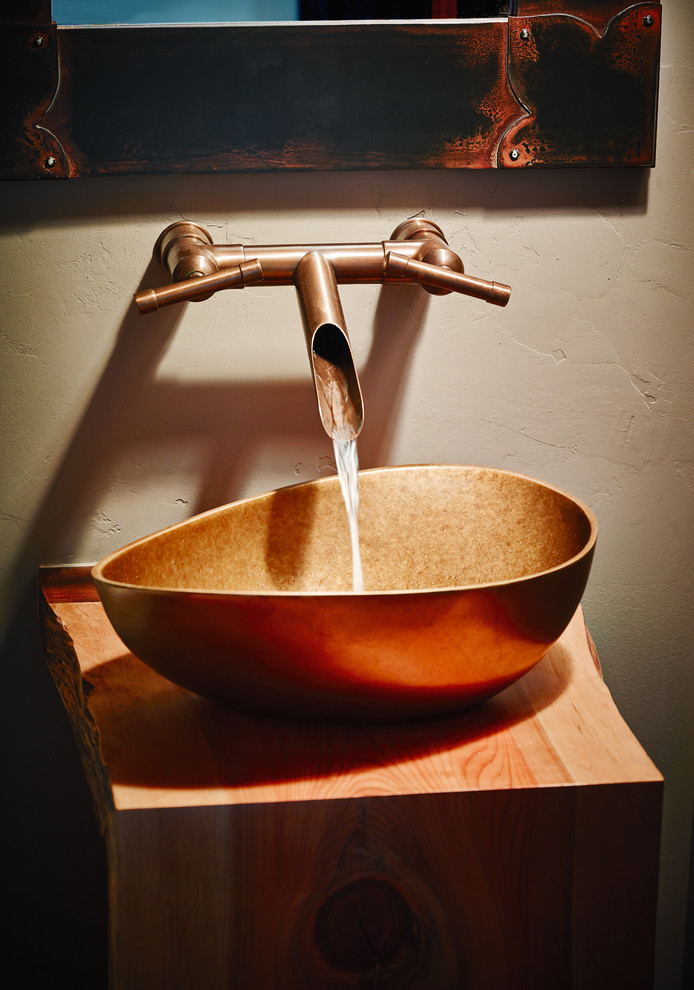 Example of a mountain style bathroom design with beige walls, a vessel sink and wood countertops