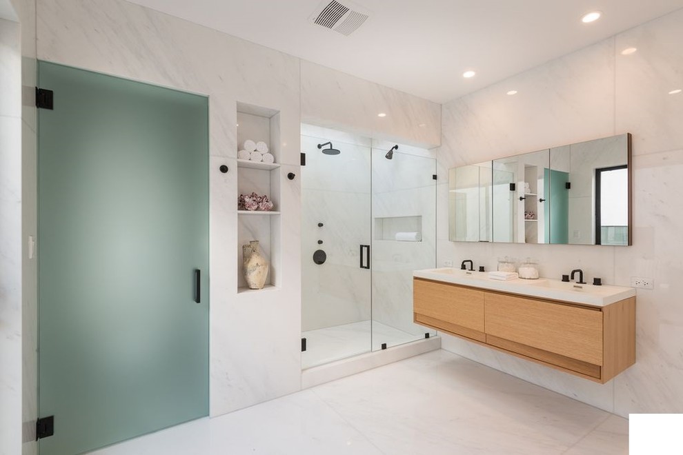 Design ideas for a mid-sized modern master bathroom in Los Angeles with flat-panel cabinets, light wood cabinets, beige walls, light hardwood floors, an undermount sink, quartzite benchtops, beige floor, white benchtops, an alcove shower, beige tile, porcelain tile and a hinged shower door.