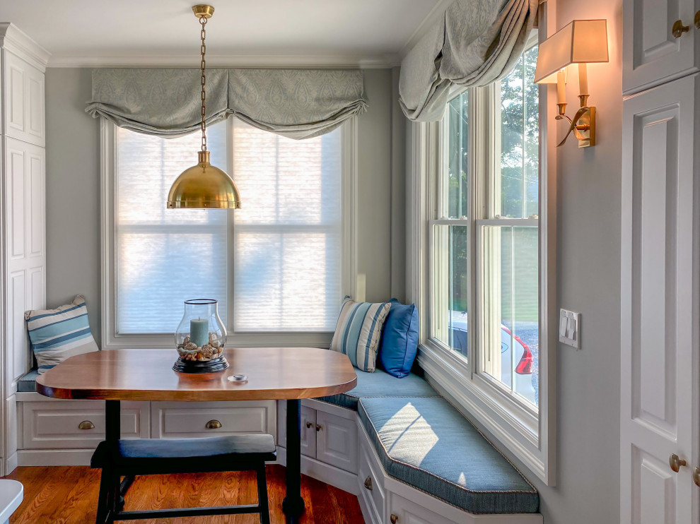 Example of a large transitional u-shaped medium tone wood floor and brown floor eat-in kitchen design in Bridgeport with an undermount sink, raised-panel cabinets, white cabinets, quartz countertops, white backsplash, glass tile backsplash, stainless steel appliances, an island and white countertops