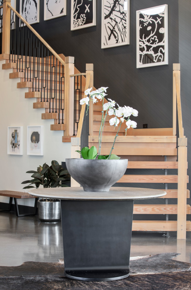 Large contemporary foyer in Portland with black walls, concrete floors, grey floor and wallpaper.