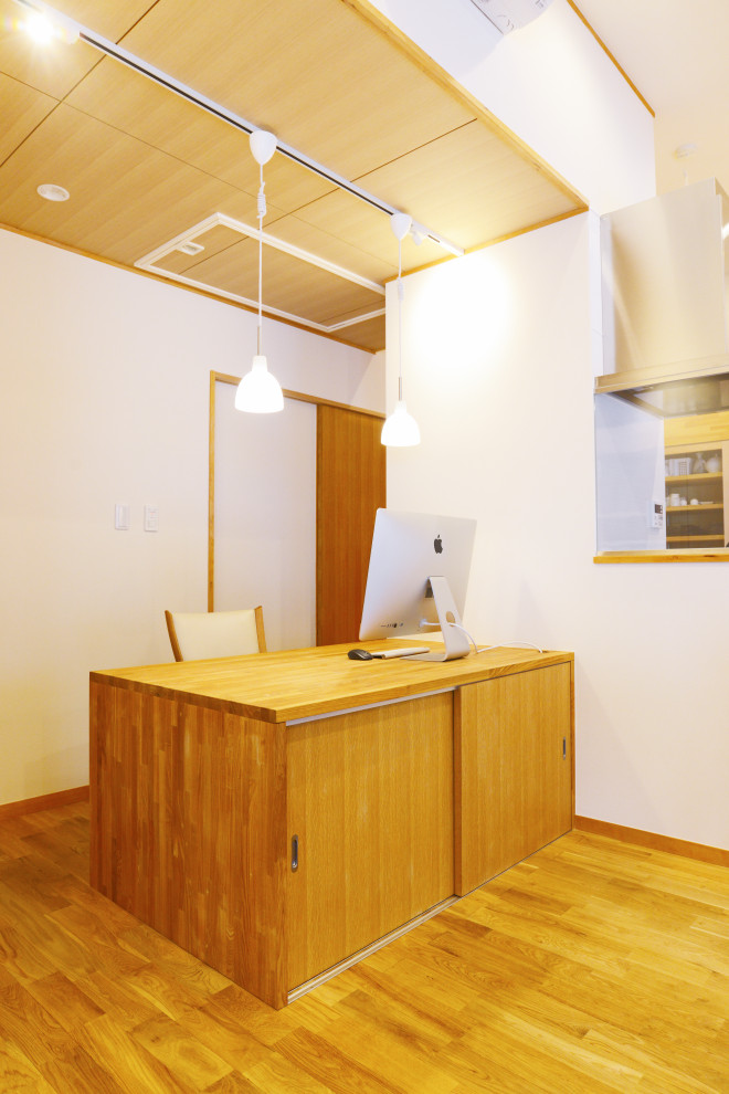 Стильный дизайн: рабочее место среднего размера в восточном стиле с белыми стенами, светлым паркетным полом, встроенным рабочим столом, бежевым полом, деревянным потолком и обоями на стенах - последний тренд