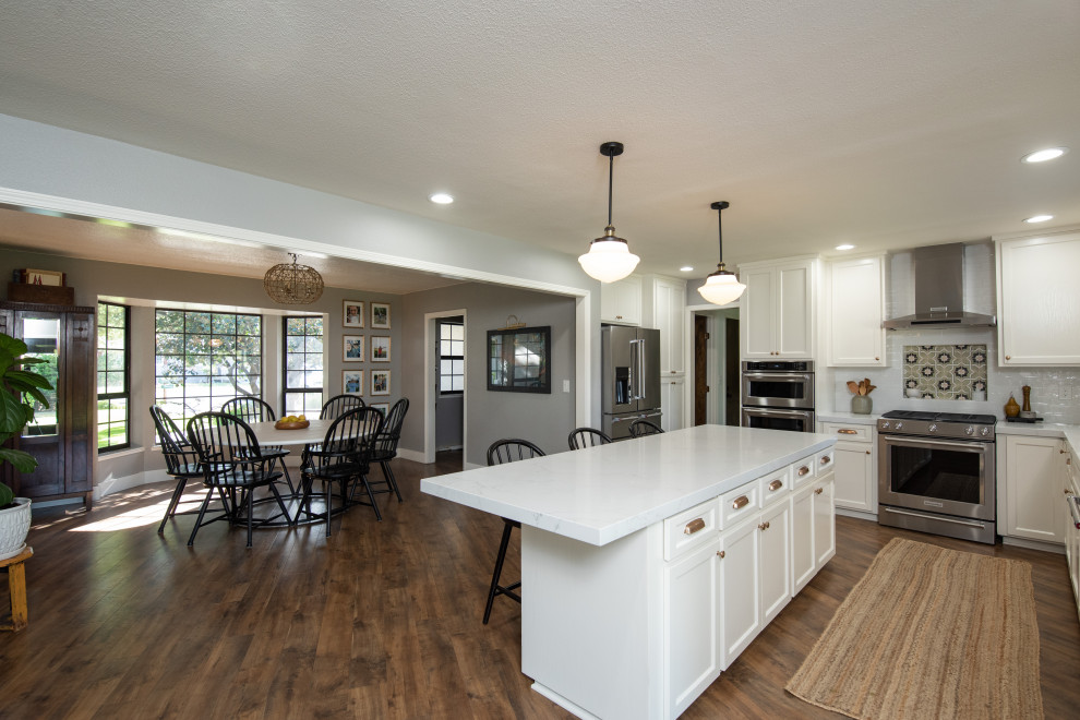 This is an example of a modern l-shaped eat-in kitchen in Sacramento with an undermount sink, shaker cabinets, white cabinets, quartz benchtops, white splashback, ceramic splashback, stainless steel appliances, with island and grey benchtop.