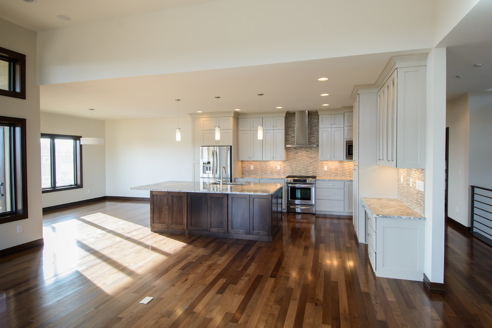 Inspiration for a transitional l-shaped medium tone wood floor open concept kitchen remodel with a farmhouse sink, shaker cabinets, white cabinets, stainless steel appliances and an island