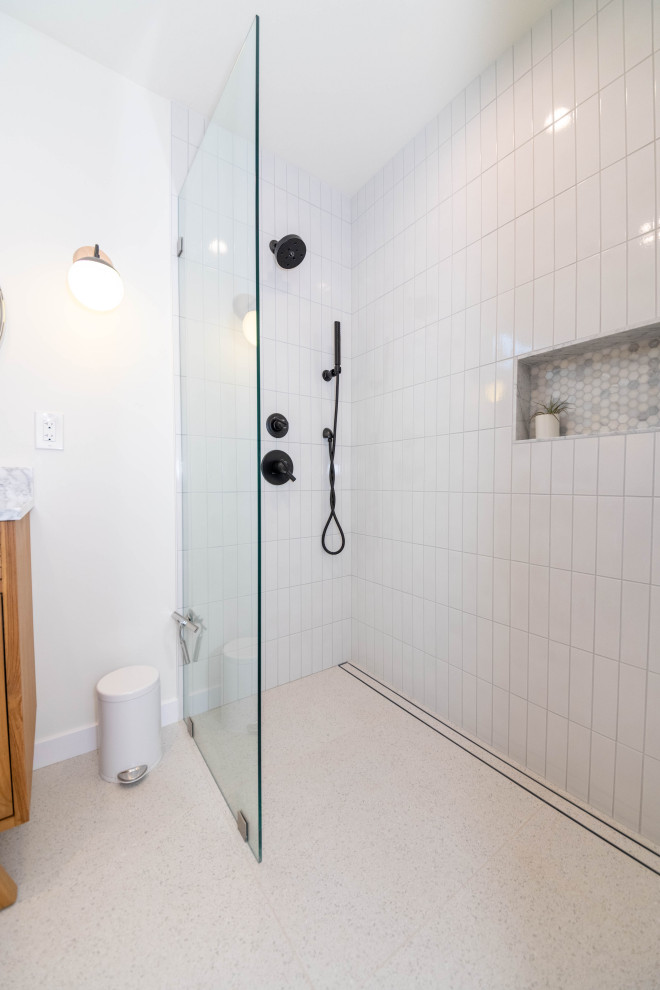 This is an example of a large modern master bathroom in Los Angeles with furniture-like cabinets, medium wood cabinets, an open shower, a wall-mount toilet, white tile, subway tile, white walls, ceramic floors, an undermount sink, quartzite benchtops, beige floor, a hinged shower door, white benchtops and a double vanity.