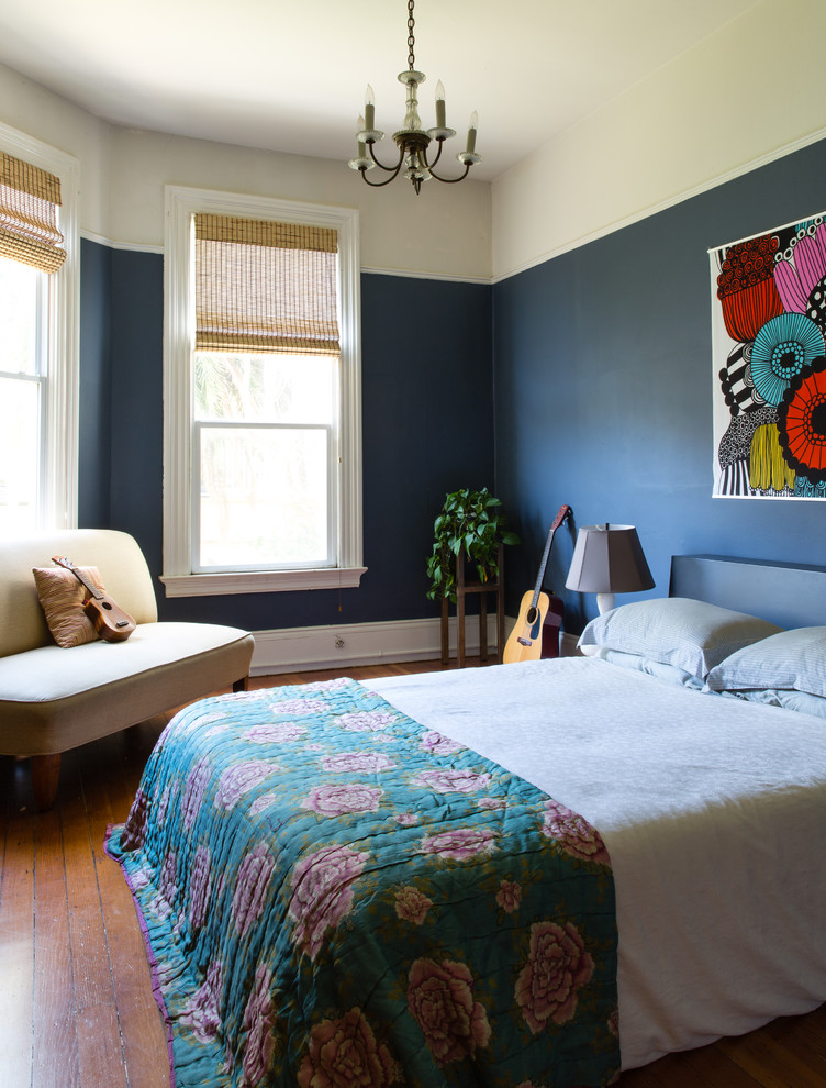 This is an example of an eclectic bedroom in San Francisco with blue walls, medium hardwood floors and orange floor.