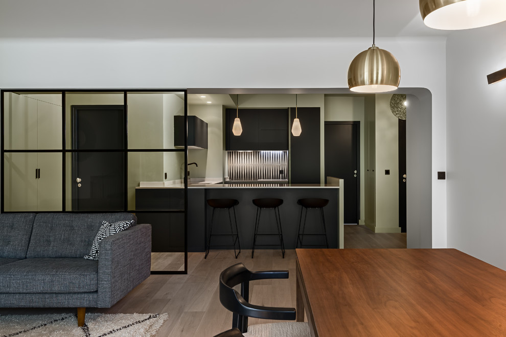 This is an example of a small contemporary u-shaped eat-in kitchen in Paris with an integrated sink, flat-panel cabinets, black cabinets, quartzite benchtops, white splashback, cement tile splashback, panelled appliances and a peninsula.