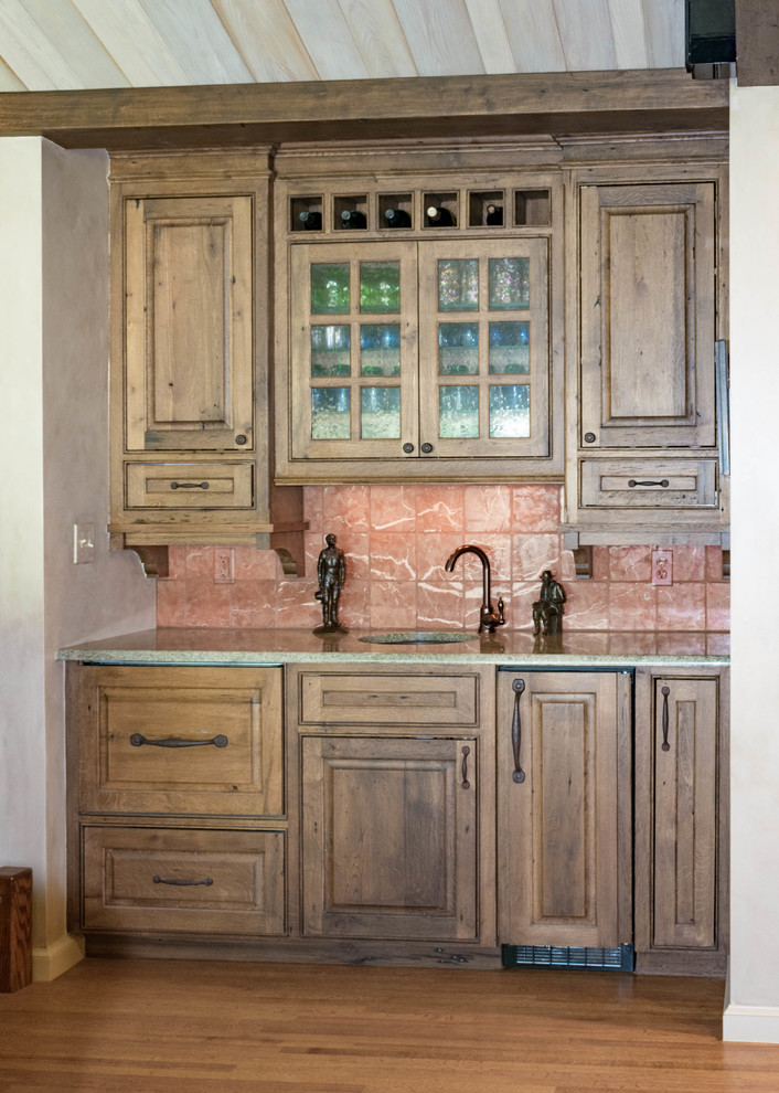 Large mountain style u-shaped eat-in kitchen photo with distressed cabinets, granite countertops, stone slab backsplash, stainless steel appliances and an island