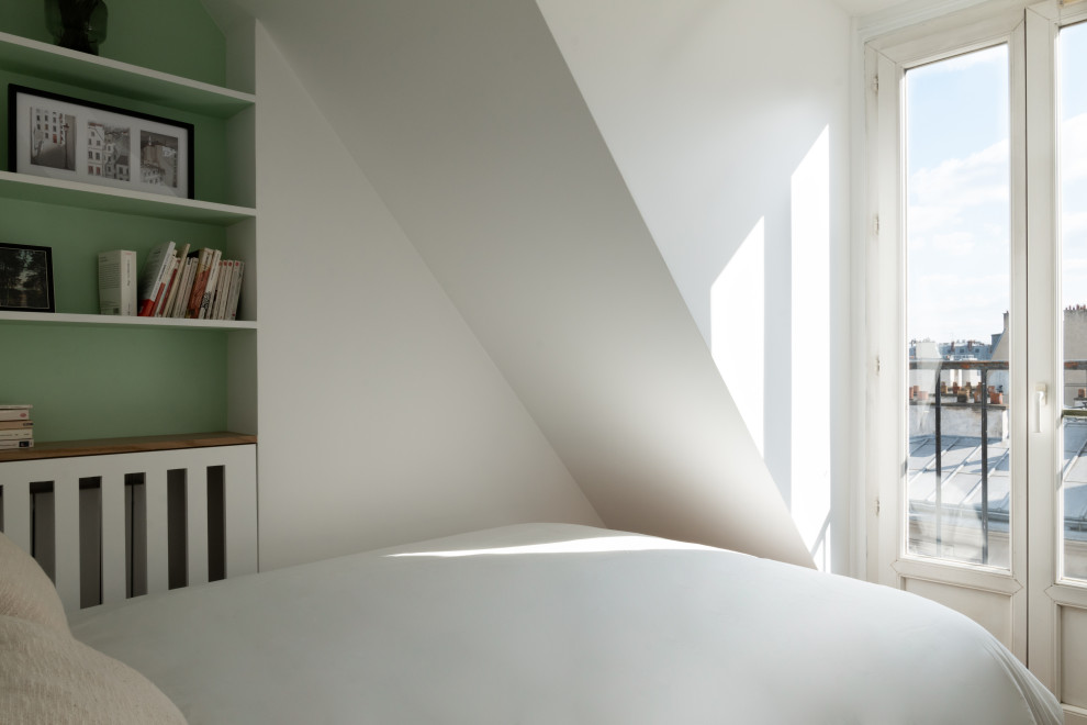 Small contemporary mezzanine bedroom in Paris with white walls and medium hardwood flooring.
