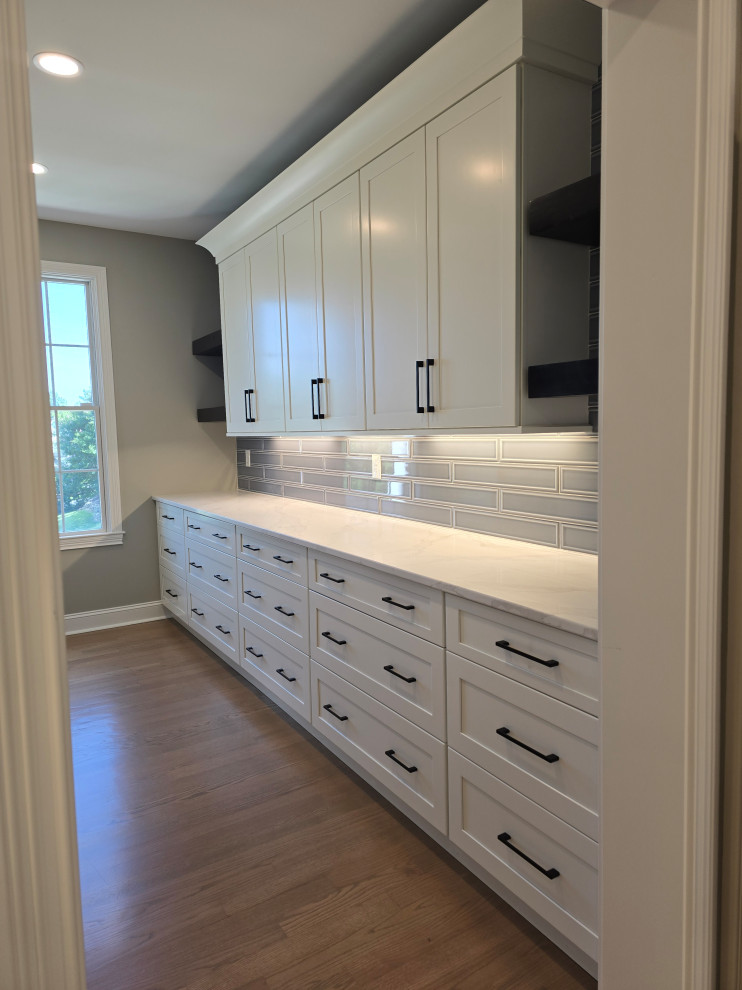 Enclosed kitchen - large modern single-wall medium tone wood floor and brown floor enclosed kitchen idea with shaker cabinets, white cabinets, quartz countertops, gray backsplash, subway tile backsplash and white countertops