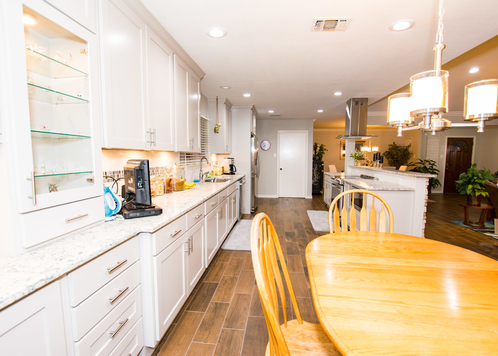 Kitchen - porcelain tile and brown floor kitchen idea in Austin with an undermount sink, shaker cabinets, gray cabinets, white backsplash, subway tile backsplash, stainless steel appliances, a peninsula and quartz countertops