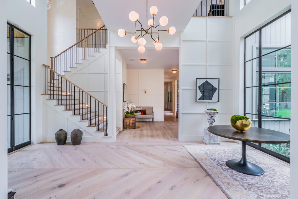Photo of a transitional entryway in Los Angeles with white walls, light hardwood floors, a green front door and beige floor.