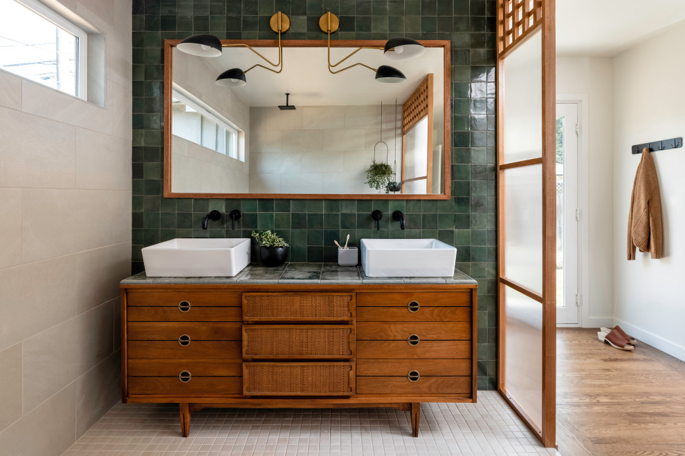 Design ideas for a mid-sized transitional master bathroom in Sacramento with brown cabinets, an open shower, green tile, subway tile, green walls, ceramic floors, a vessel sink, tile benchtops, white floor, an open shower, green benchtops, a shower seat, a double vanity and a freestanding vanity.